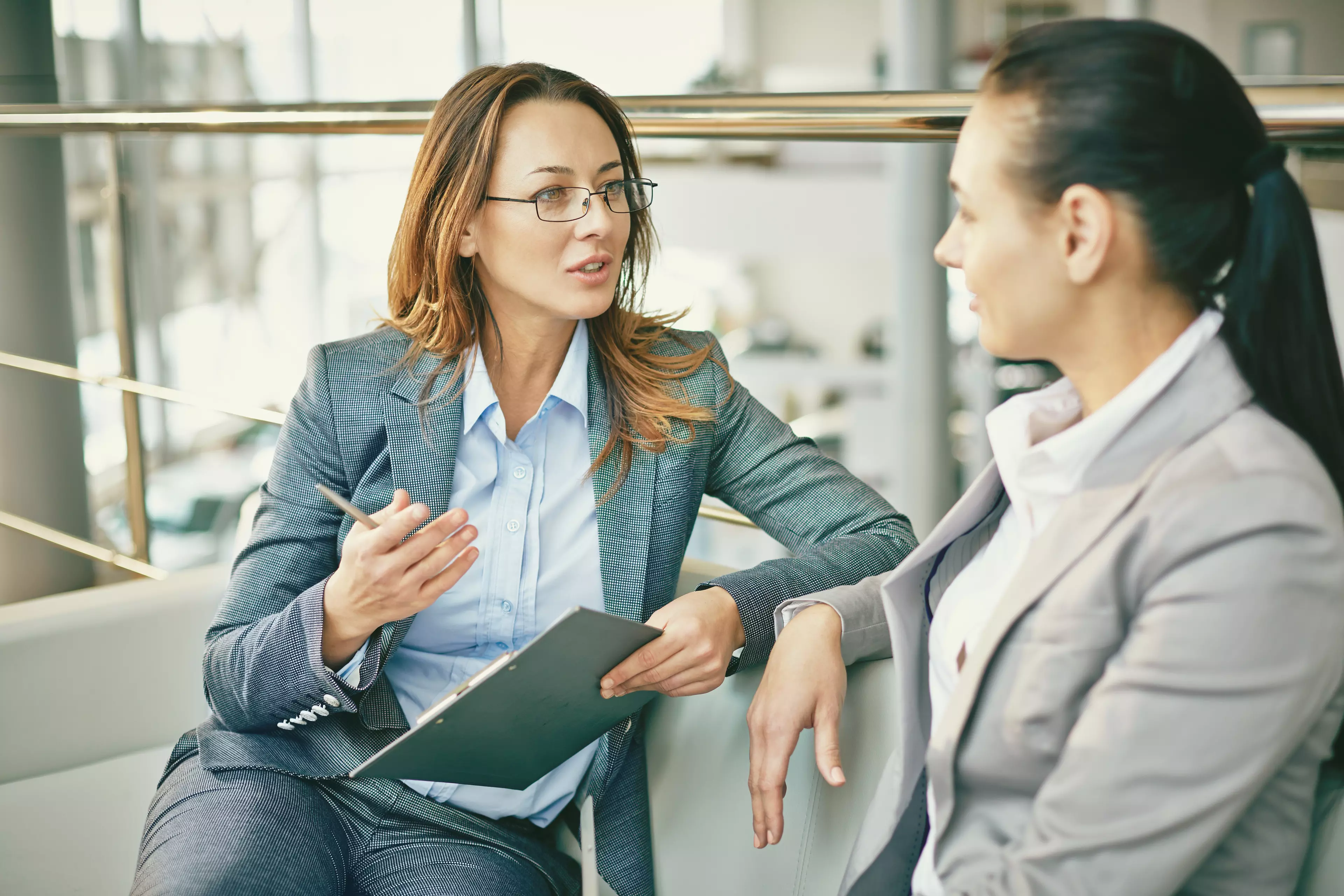 Two businesswomen having a conversation in an office.