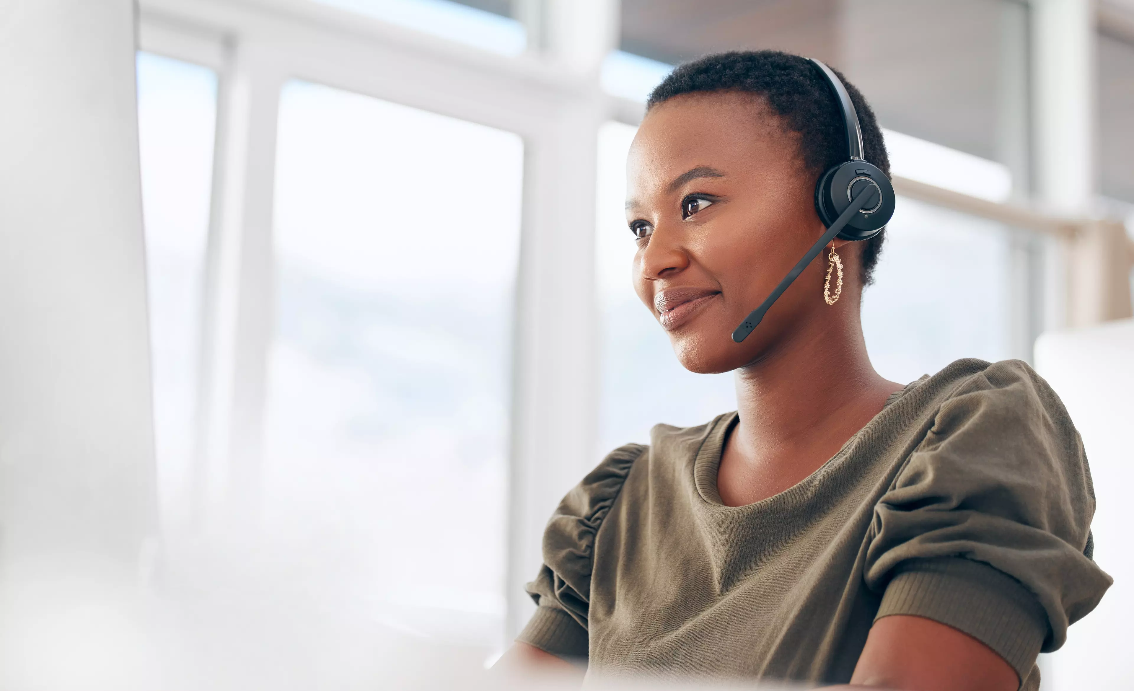 Young, smiling, short-haired woman with a headset on.