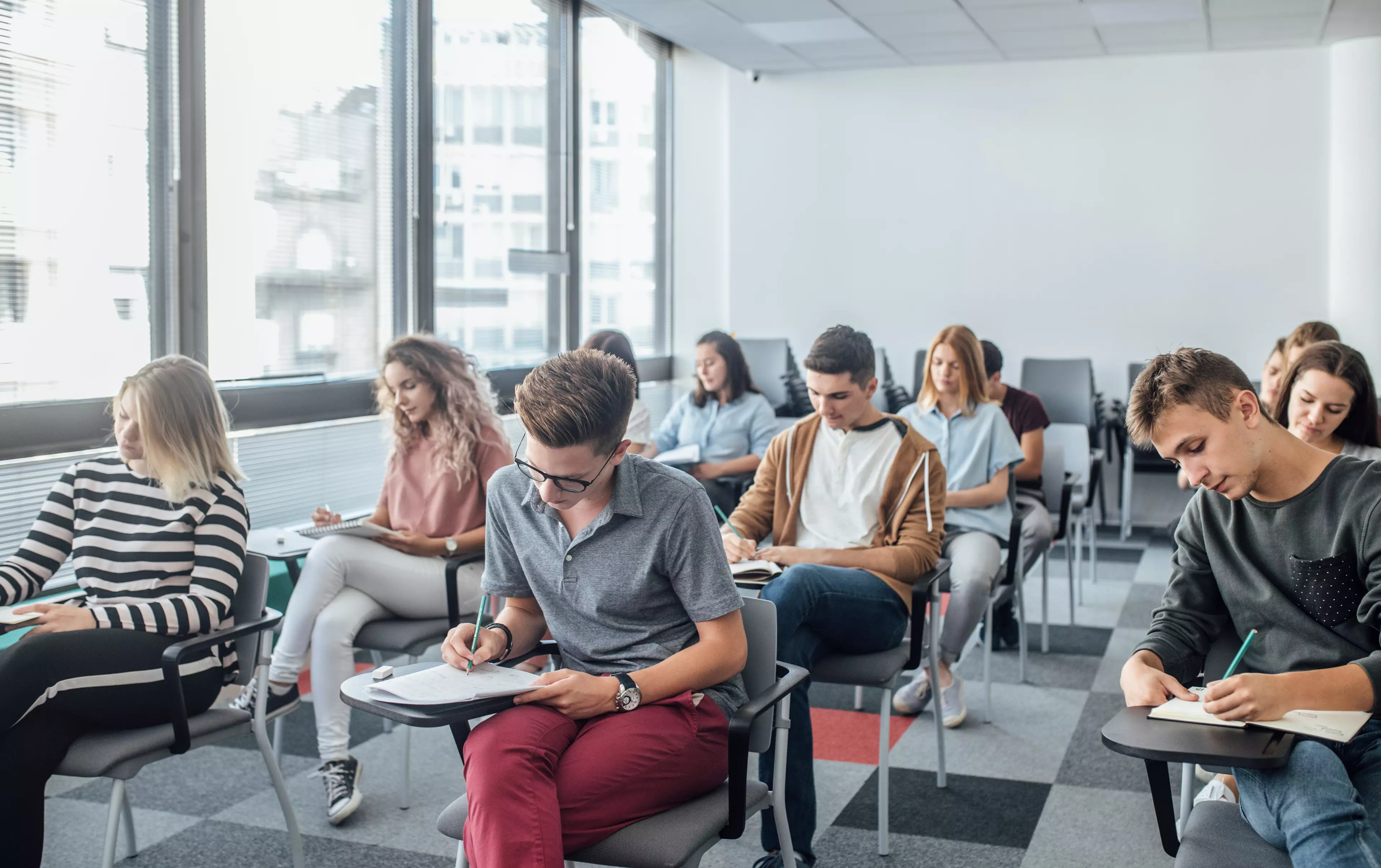 Room full of young adults sitting behind desks and taking an assessment