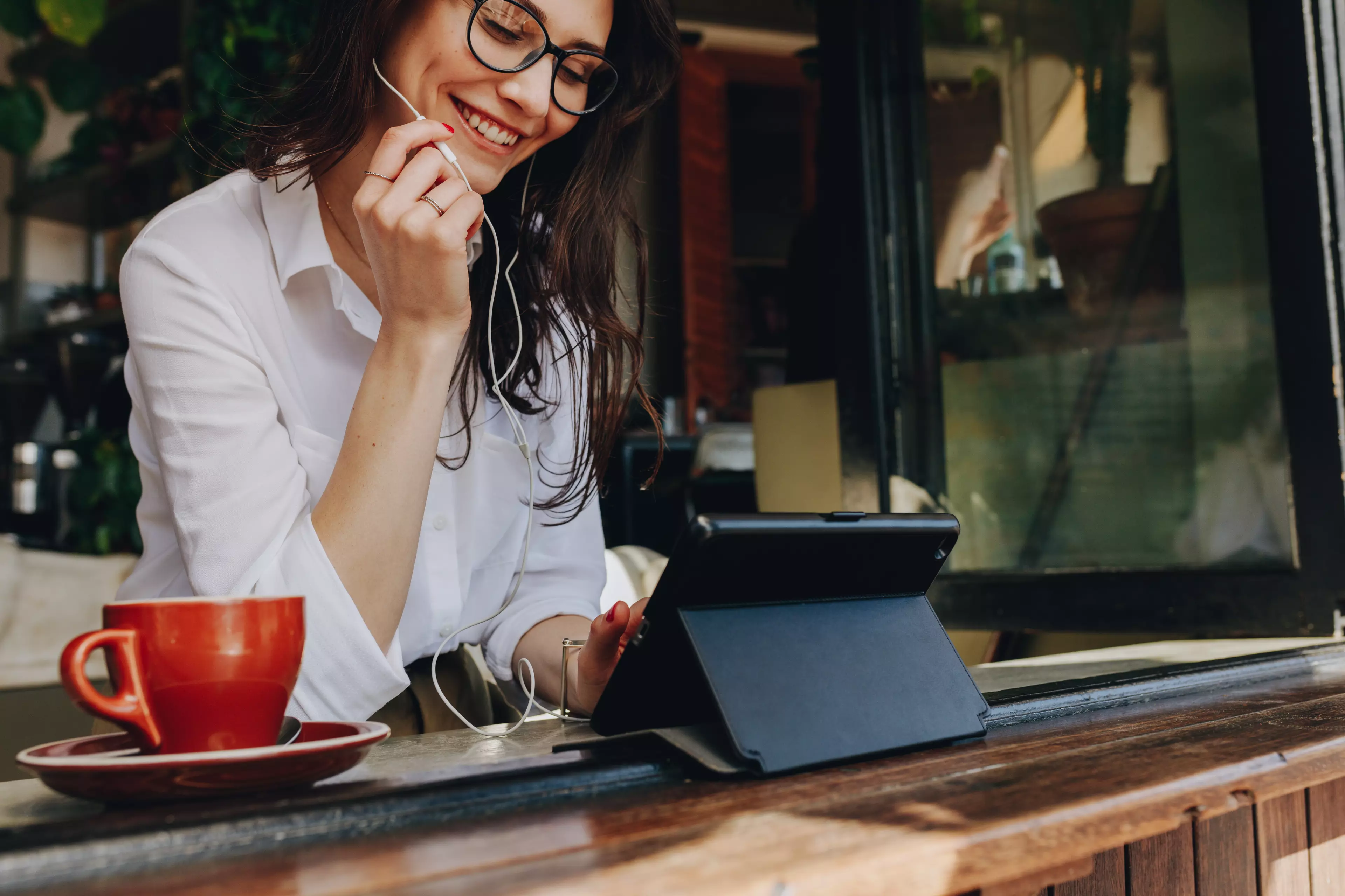  Smiling woman talking over a video messaging app on a tablet.